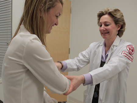Dr. Audrey Uknis examines her patient with rheumatoid arthritis.