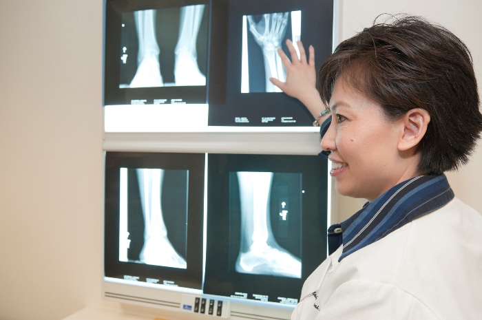 A rheumatologist discussing an X-Ray image, symbolizing the patient-doctor relationship necessary for positive outcomes