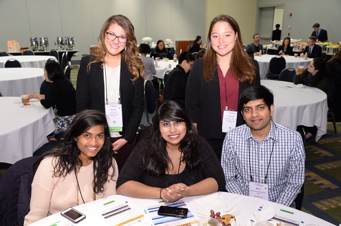 Four rheumatology students smiling at a table during the Foundation student and resident experience